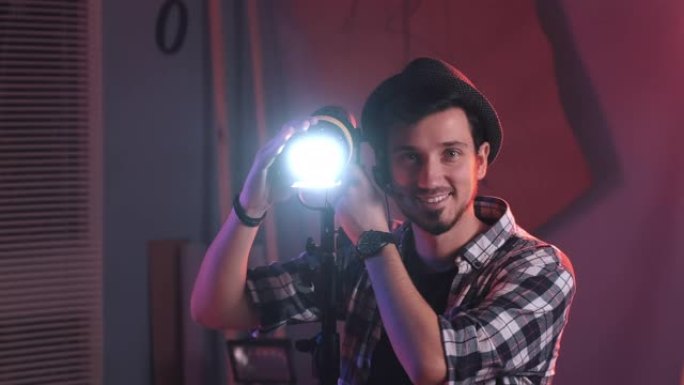 男性电影制片人在演播室调整专业灯架，照明
