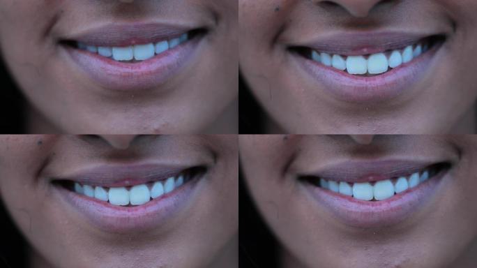 女孩嘴巴微笑的特写。漂亮的非洲裔美国年轻女子嘴唇裂开微笑