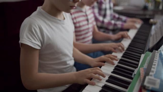 三个孩子一起弹数字钢琴
