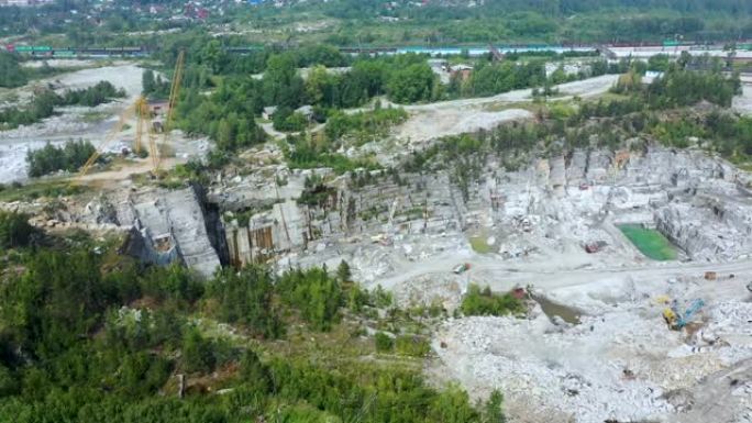 挖掘机在采石场中移动刚爆破的岩石的俯视图上升