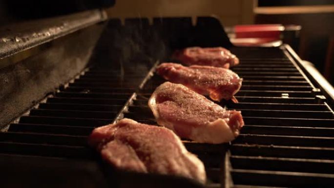晚上在室外的热烤架上烤和烹饪调味的、未煮熟的、去骨的里脊肉猪排