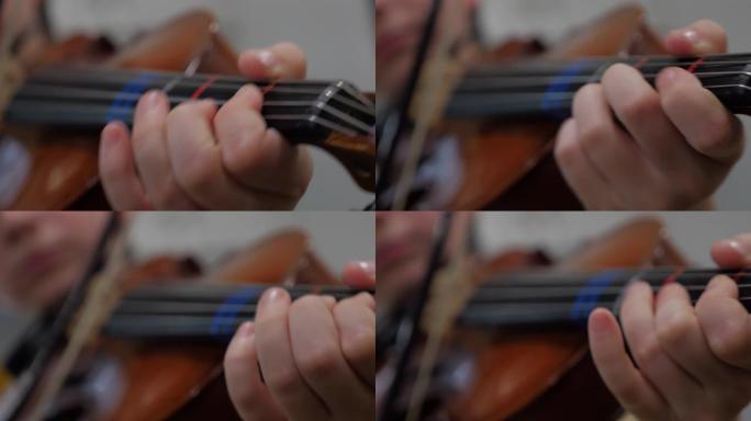一个小男孩的手指拉小提琴的特写