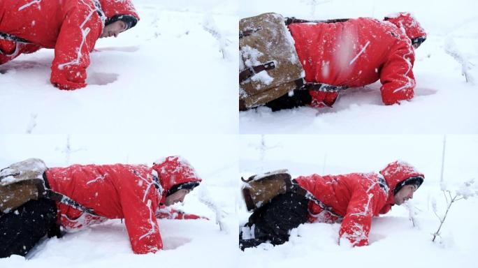 疲倦的旅行者或登山者正试图从雪山下走出来。一个在雪地里爬行的人。