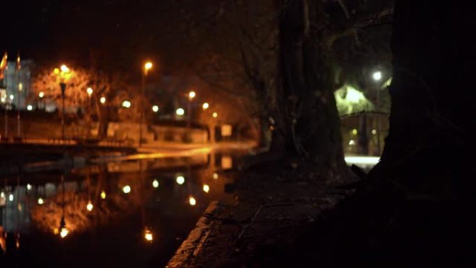 秋夜城市街道雨后路灯倒映雨水坑