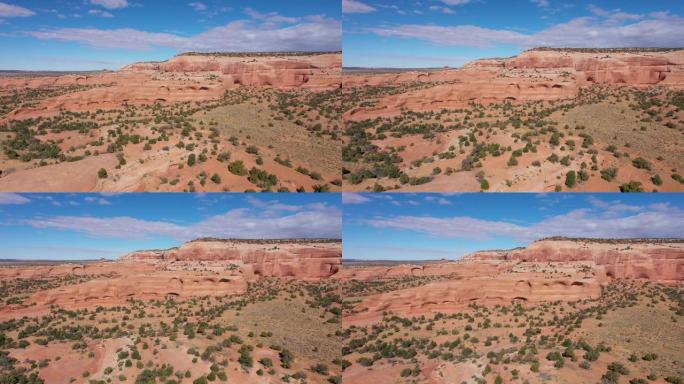 无人机在美国沙漠的橙色石头阵列岩层附近飞行