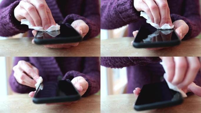 带有抗菌白色纸巾或一次性湿巾的智能手机的女性清洁显示器