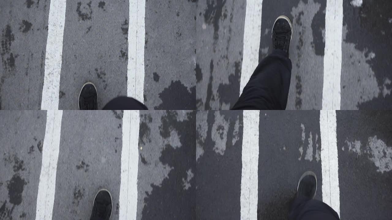 在湿沥青人行道上行走自由的概念。穿着运动鞋往下看