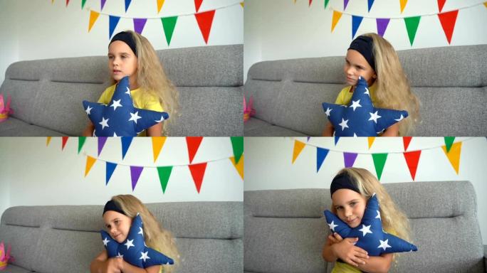 卷发女孩拥抱星星形状的枕头，看电视坐在沙发上。万向节运动