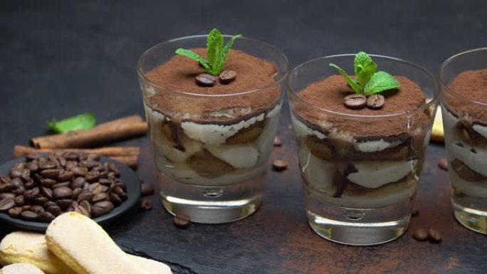经典提拉米苏玻璃杯甜点和石头上菜板上的瓢虫饼干