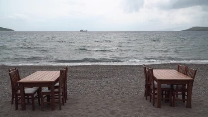 海滩上的空桌子和椅子。