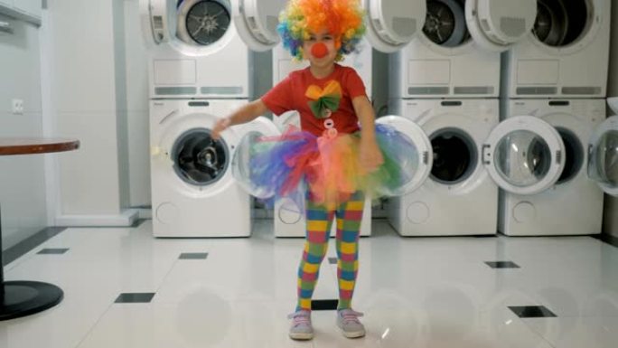 快乐的小丑小女孩跳舞，在洗衣房玩得开心。小孩子小丑喜欢跳舞，一起玩得开心，派对。牙线舞蹈病毒，牙线。