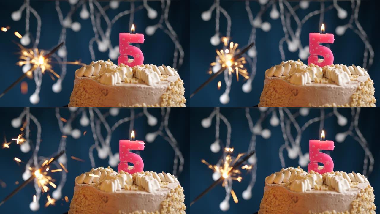 生日蛋糕，蓝色背景上有5个数字粉色蜡烛和烟火。慢动作和特写视图