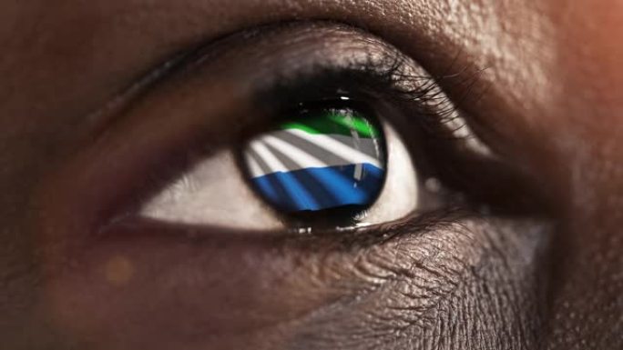女子黑眼圈在近距离与国旗塞拉利昂在iris与风的运动。视频的概念