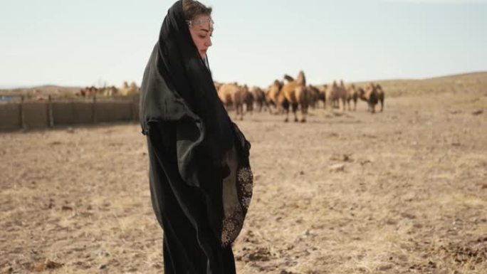 美女民族黑衣，阿巴亚，散步草原骆驼，沙漠，慢慢