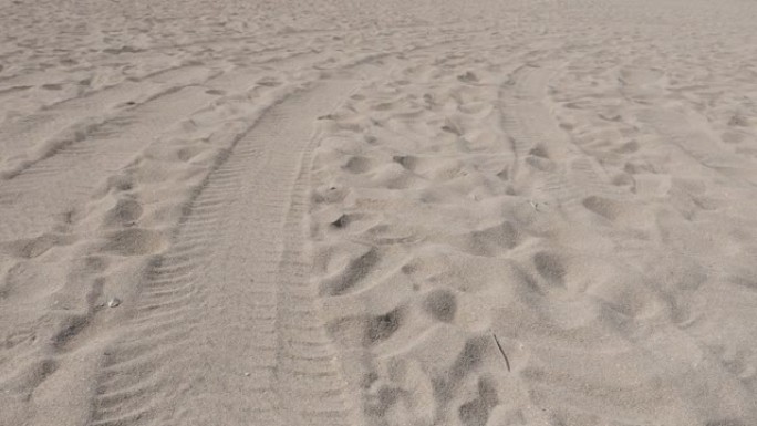 海滩细海砂造粒，带脚印和轮胎步道4K