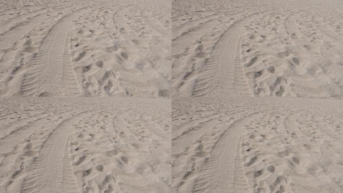 海滩细海砂造粒，带脚印和轮胎步道4K
