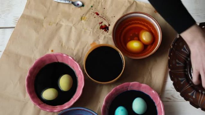 为复活节做准备。女人用不同的颜色画复活节彩蛋