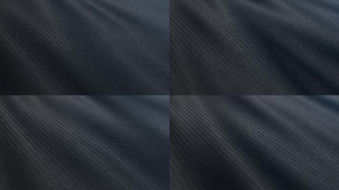 黑色织物布料是波浪的。时尚图案，细节粗麻布。