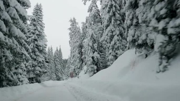 汽车POV在积雪覆盖的道路上行驶，第一场雪落下。