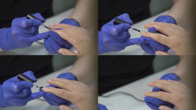专业美甲师手套用透明清漆覆盖指甲。特写镜头。4k实时镜头。