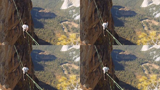 男人的背部坐在松紧的绳索上的镜头，可以欣赏山谷的壮丽景色
