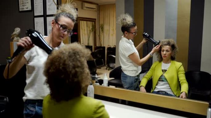 健康的发梢。一名女客户在当地美容院理发的镜头