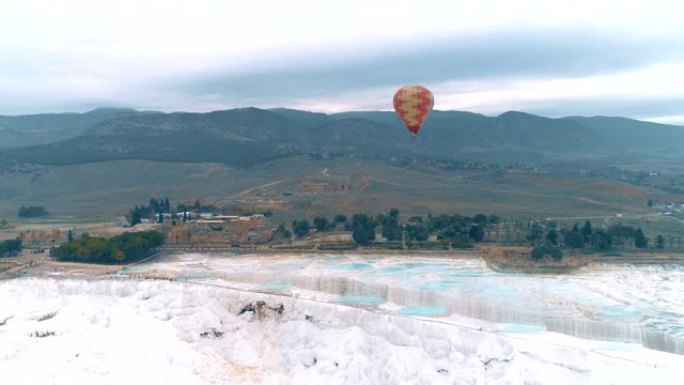 热空气气球在土耳其德尼兹利的棉花堡石灰华上空飞行