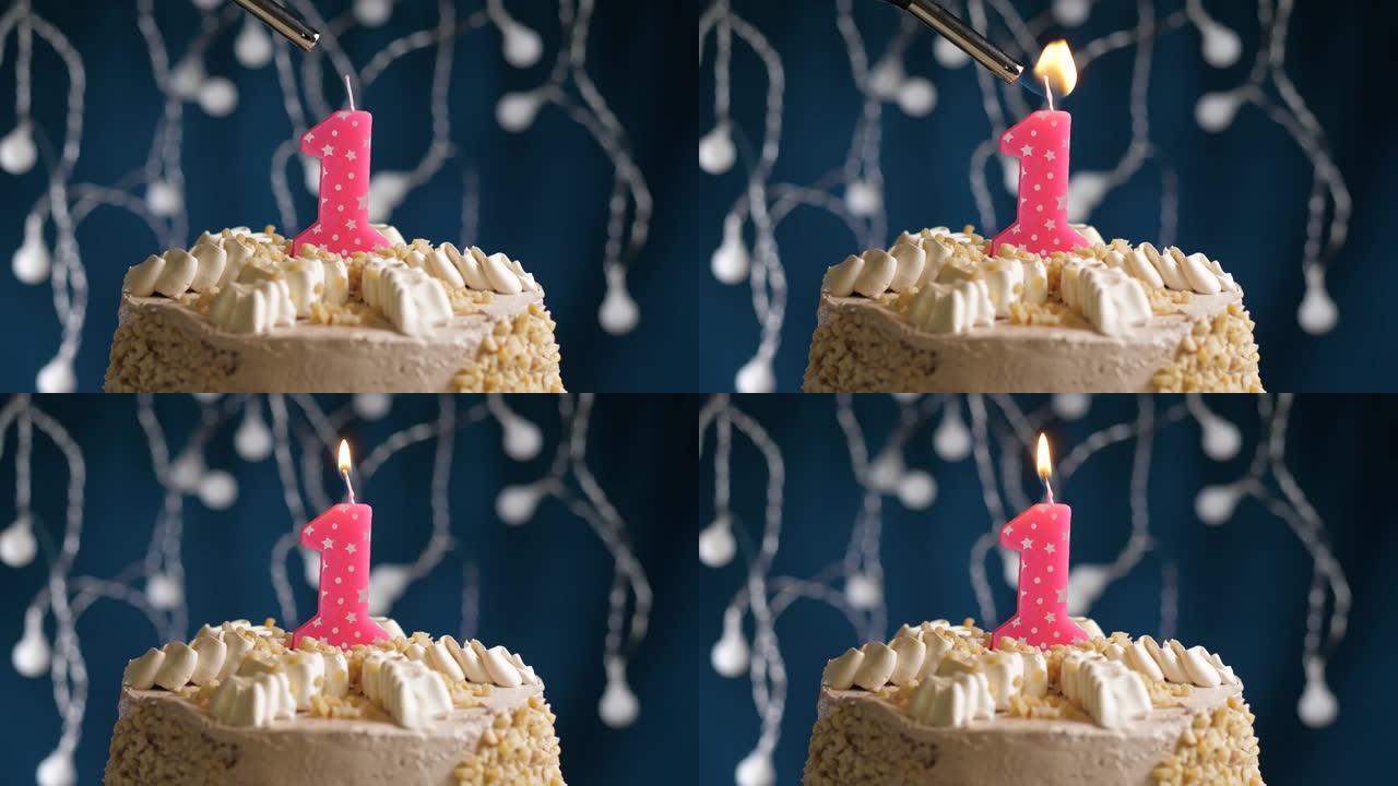 蓝色背景上有1号粉色蜡烛的生日蛋糕。蜡烛着火了。慢动作和特写视图