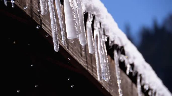 冰柱融化，滴在挂在木屋屋顶上的阳光下。慢动作
