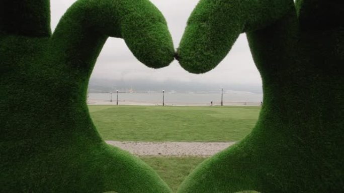 大草木手在海边的公园里做心形