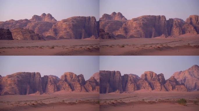 在阳光明媚的日子里，在约旦的瓦迪朗姆酒沙漠中行走的骆驼大篷车