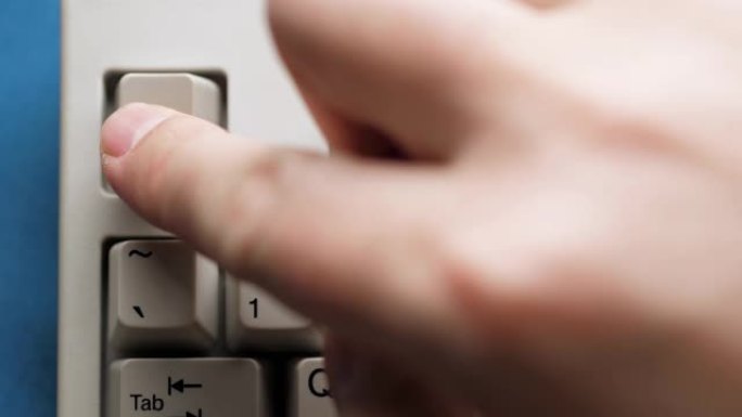 男性手指按下白色键盘上的ESC按钮。慢动作和宏观视图