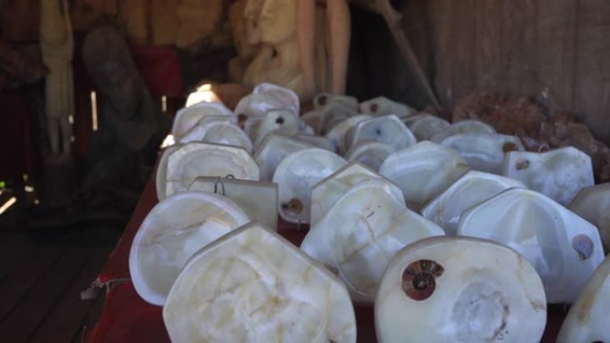 在马达加斯加塔那那利佛的纪念品市场上展出的带有菊石化石的白色抛光石头，形成小碗或烟灰缸