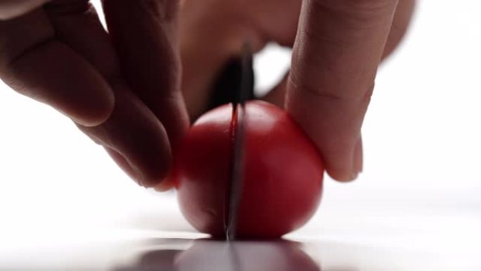 在白色背景上慢动作的番茄切割特写