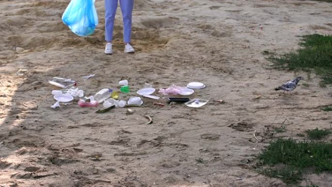 女志愿者帮助清理海滩上的垃圾。很多垃圾躺在沙滩上