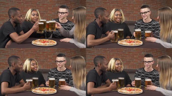 两对年轻夫妇在酒吧玩得开心。人们正在喝啤酒和吃披萨。休闲概念。多种族友谊