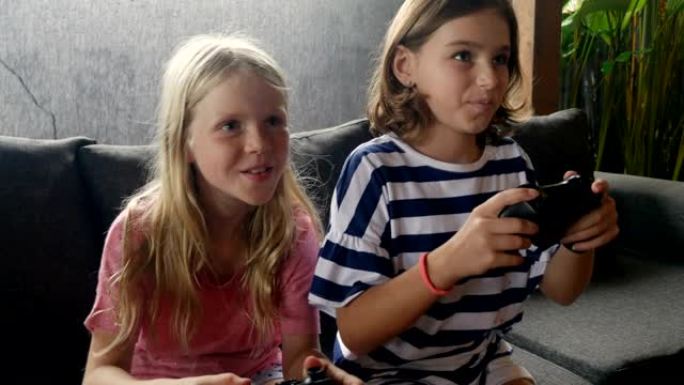 两个快乐微笑的年轻女孩一起玩电子游戏