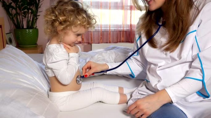女医生护士在床上用听诊器检查生病的可爱的小女孩