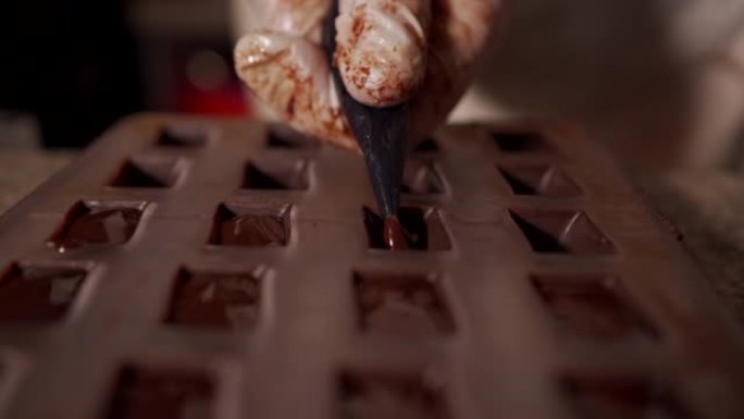 糕点面包师用融化的巧克力馅料填充糕点袋填充模具