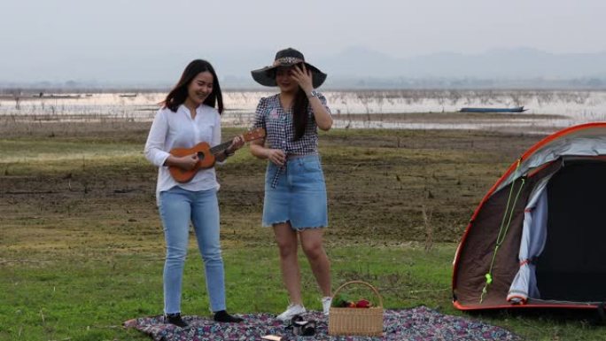 一群亚洲朋友在暑假玩Ukelele，花时间野餐。他们在假期很开心，玩得开心。他们用笔记本工作