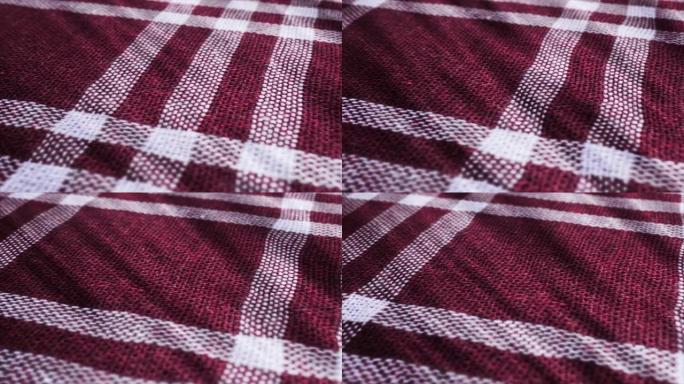 桌布，野餐方格布是平移相机运动。特写微距拍摄方格红红色布料背景。