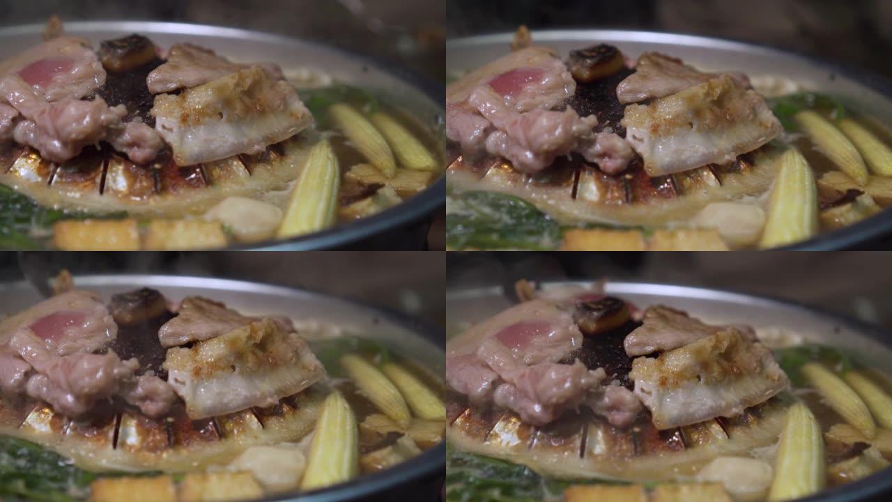 生猪肉在热锅上烧烤。泰式火锅烧烤。周围有蔬菜。慢动作。