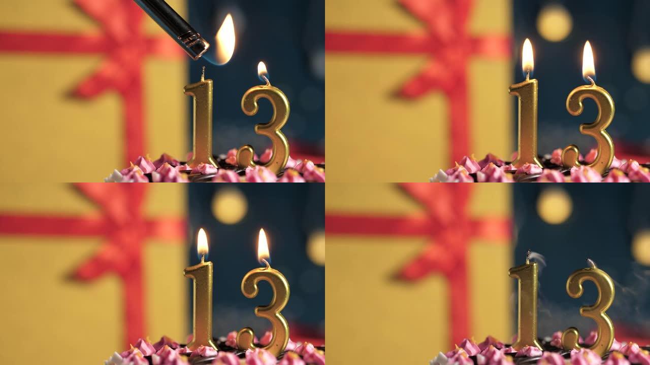 生日蛋糕13号点火器燃烧的金色蜡烛，蓝色背景礼物黄色盒子用红丝带绑起来。特写和慢动作