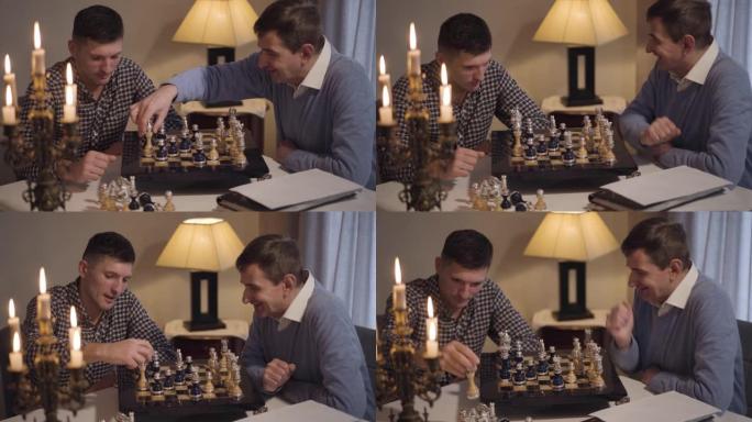 两个积极的白人男子参加国际象棋比赛。父子俩晚上坐在桌旁。爱好，生活方式，家庭