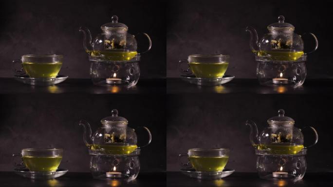 厨房茶杯里的热绿茶。经典茶壶由玻璃和蜡烛烧开水制成。热饮和茶时间概念。