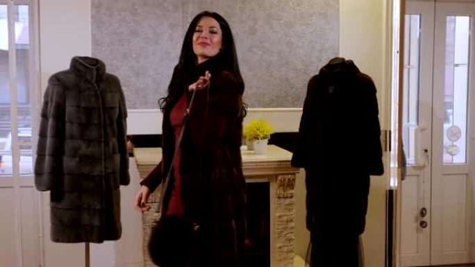 一个长发的豪华女孩在一家女装商店试穿皮大衣。