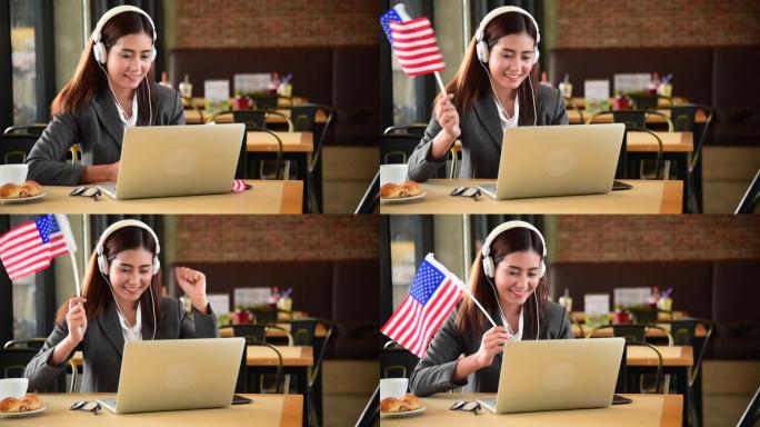 商业女性从笔记本电脑上观看在线体育，挥舞着美国国旗欢呼美国。