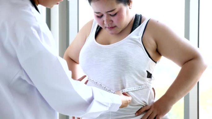 医生在临床用卷尺测量超重妇女的脂肪层