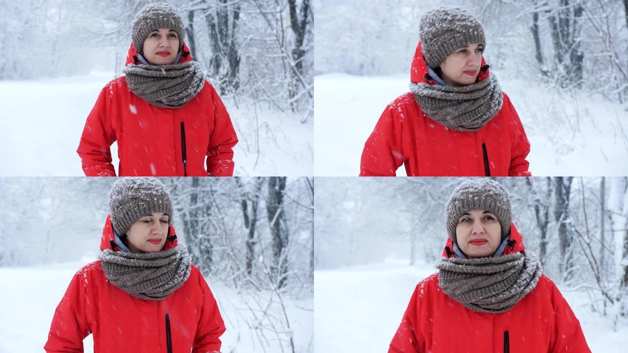 穿着红色夹克的女人在镜头前走在白雪覆盖的道路上。
