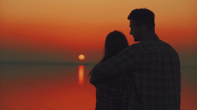 男人和女人站在风景秀丽的日落前